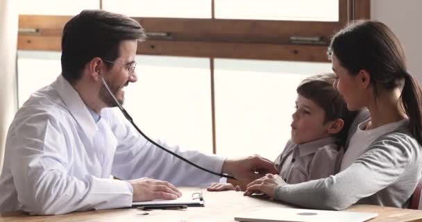 Sorrindo médico masculino segurando estetoscópio examinando menino ouvindo paciente menino — Vídeo de Stock