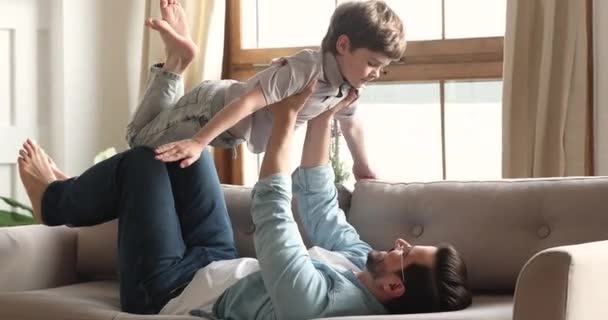 Menino pré-escolar jogando avião jogo voando nos braços dos pais — Vídeo de Stock