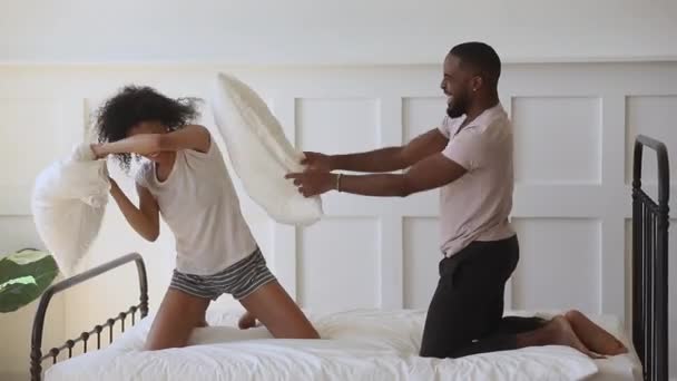 Молодая семейная пара смешанной расы сражается с подушками . — стоковое видео