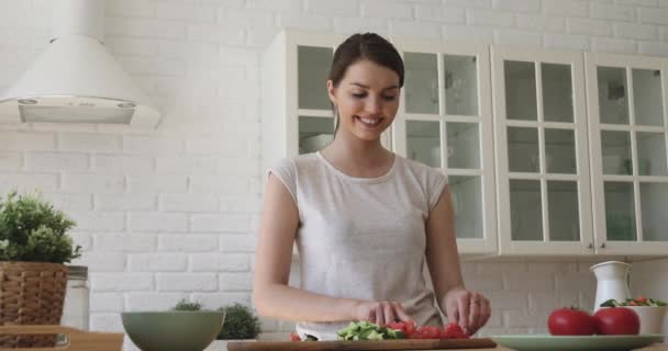 Šťastná mladá žena v domácnosti se těší přípravě zdravé vegetariánské jídlo. — Stock video