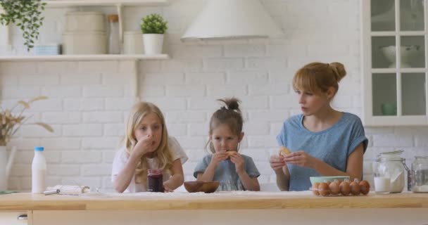Glada små barn och mamma äter hembakade kakor med sylt. — Stockvideo