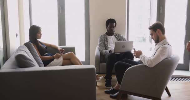 Mixed race young people using different gadgets at office hall. — Stock Video