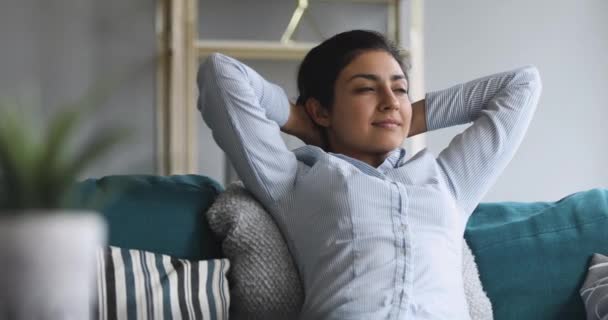 Χαλαρωμένη Ινδή που αναπαύεται σε άνετο καναπέ στο σαλόνι — Αρχείο Βίντεο