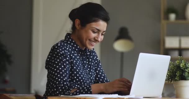 Lächelnde indische Studentin tippt auf Laptop, um Kurs vorzubereiten — Stockvideo