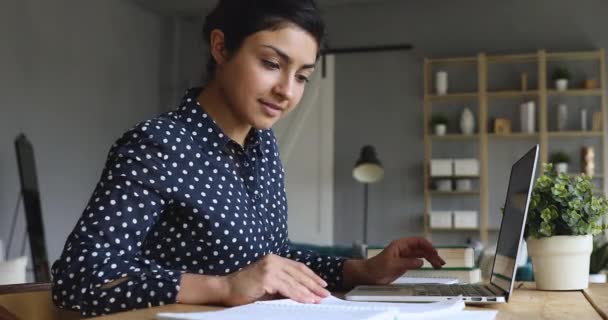 Chica india estudiando notas de lectura en el libro de ejercicios con portátil — Vídeo de stock