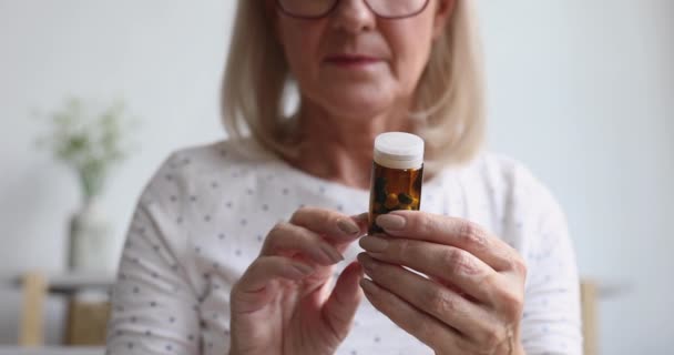 Mulher velha segurar frasco pílula analgésica ler prescrição, close-up — Vídeo de Stock