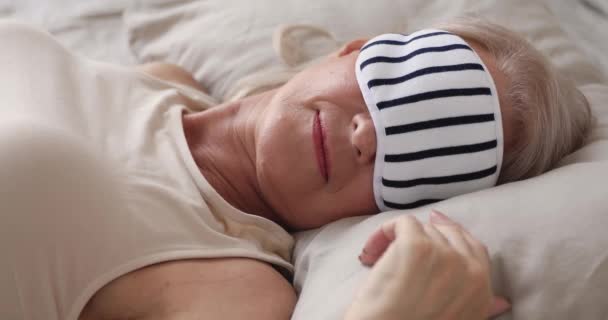 セレン健康的な老婦人は、ベッドの中で睡眠マスク睡眠を着用 — ストック動画