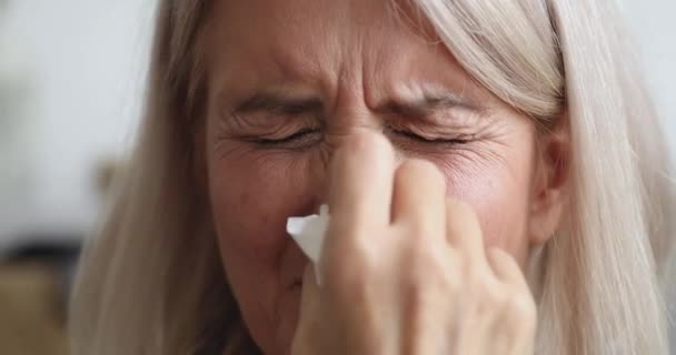 Allergic ill old woman holding tissue sneezing, close up view — Stock Video