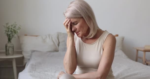 Molesto anciana madura cansada afrontamiento con concepto de dolor de cabeza por la mañana — Vídeos de Stock