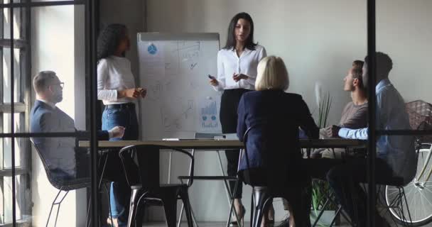 Entrenador femenino caucásico trabajando con presentadora africana dar la presentación — Vídeos de Stock