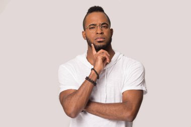 Düşünceli siyah erkek stüdyoda izole edilmiş satış teklifini düşünüyor.