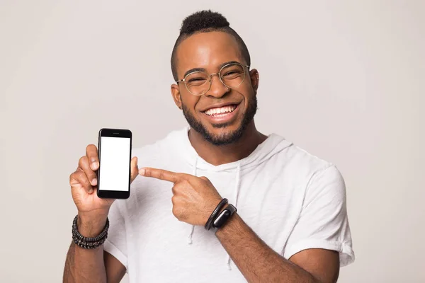 Smiling black man look at camera point at smartphone screen — Stock Photo, Image