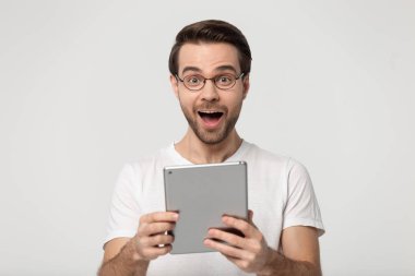 Excited young man holding digital gadget portrait. clipart