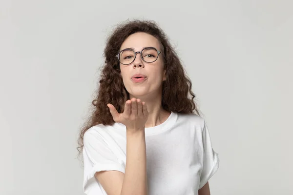 Kopfschuss Porträt attraktive Frau mit Brille sendet Luftküsse. — Stockfoto