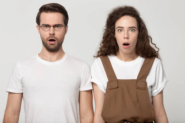 Unpleasantly surprised millennial couple looking at camera. — Stock Photo, Image