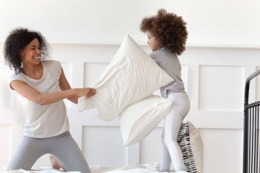 Afrikalı anne küçük kızıyla yastık savaşı yapıyor.