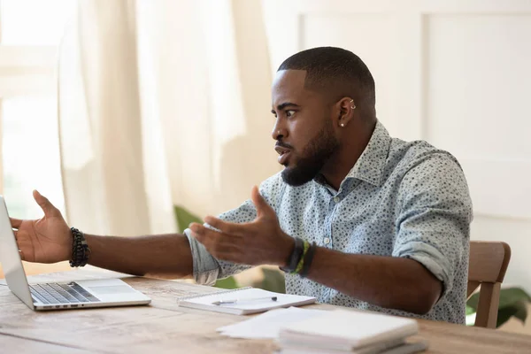 African guy looks at pc screen talking feels outraged — Stock Photo, Image