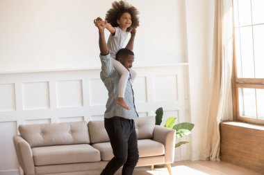 Küçük kız babasının omuzlarında oturmuş içeride eğleniyor.