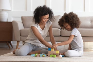 Anne ve kızı evde oyuncak bloklarıyla oynuyorlar.