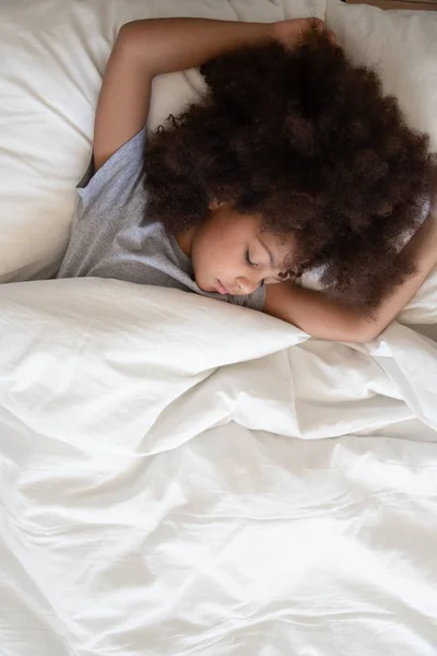Gadis afrika kecil yang manis tidur di tempat tidur pandangan dari atas — Stok Foto