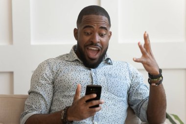 Afrikalı adam ağzını açıp akıllı telefon ekranına baktığında hayrete düşüyor.