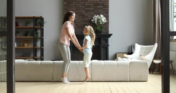 Радісна матуся танцює стрибає з милою маленькою донькою . — стокове відео