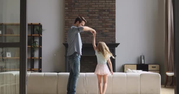 Handsome young father twisting little princess daughter, kissing hand. — Stock Video