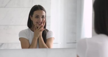 Genç ve mutlu bir kadının yumuşak tene dokunuşunun ayna yansıması..