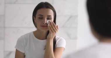 Makyaj malzemesi kullanan çekici genç bir kadın..