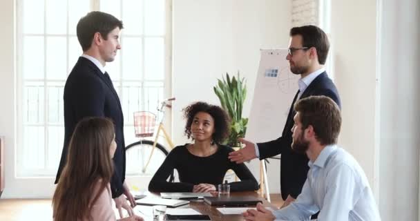 Two business partners shake hands at board group meeting table — Stockvideo