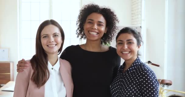 Três felizes amigável diversificada etnia mulheres abraçando ligação dentro de casa — Vídeo de Stock