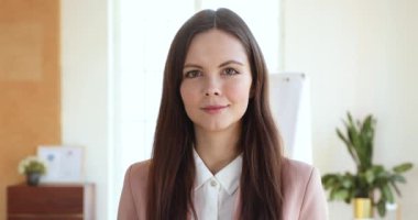 Smiling confident young businesswoman professional looking at camera in office