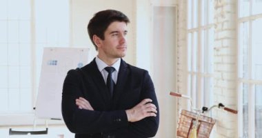 Successful happy young businessman wear suit posing in modern office