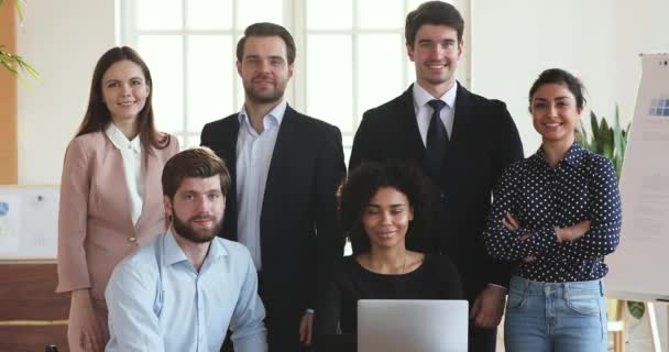 Sonriente grupo de empresarios multiétnicos posando en la oficina con el ordenador portátil — Vídeo de stock