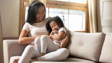 Evde oynayan neşeli genç anne ve kız.