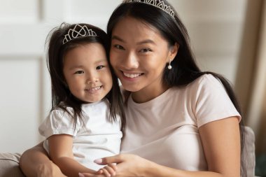 Evde poz veren Asyalı anne ve kızının portresi.