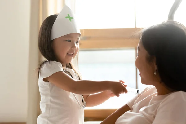 Kleine asiatische Mädchen spielen Arzt mit junge Mutter zu Hause — Stockfoto