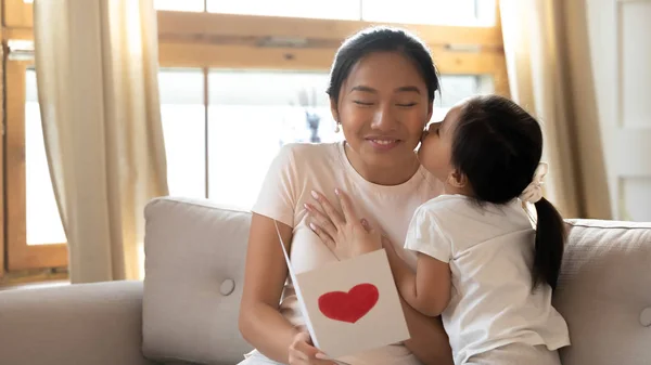 Loving little Asian girl greeting happy young mom — Stock Photo, Image