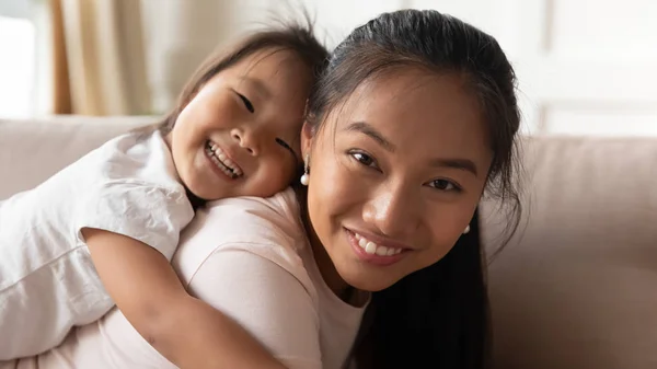 Portrait of smiling Asian mom and little daughter at home — Stock Photo, Image