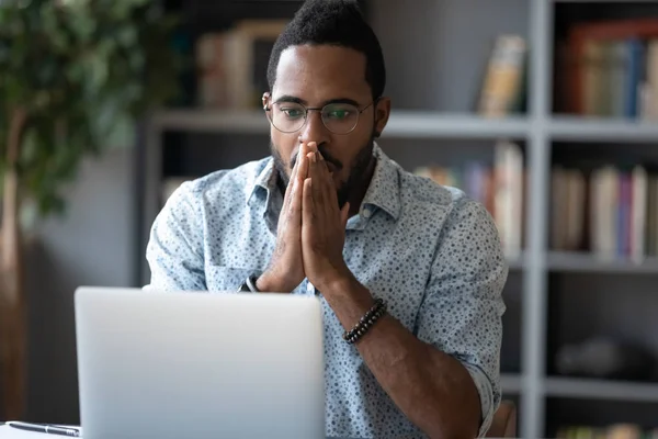Impresionado hombre de negocios africano se siente frustrado mirando a la pantalla del ordenador portátil — Foto de Stock