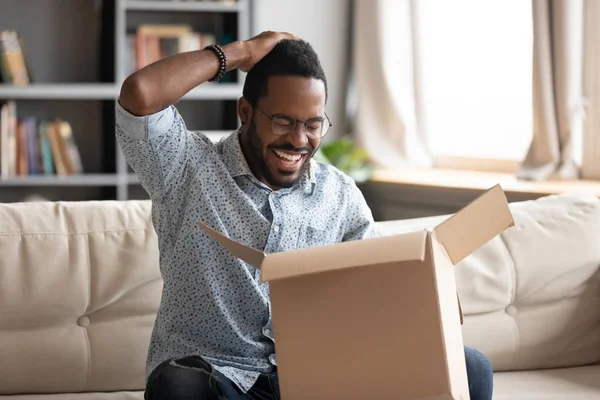 Felice africano maschio cliente tenere scatola di cartone aperto pacco postale — Foto Stock