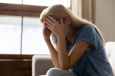 Stresli genç sarışın kadın baş ağrısı çekiyor..