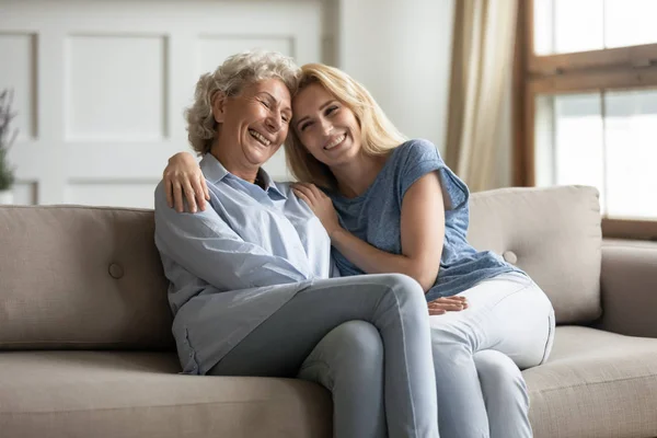 Gelukkig jong vrouw knuffelen glimlachen ouder volwassen mama. — Stockfoto