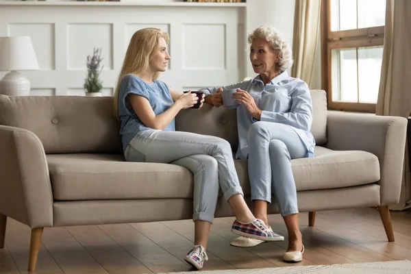 Sonriente de mediana edad madre charlando con la hija adulta . — Foto de Stock