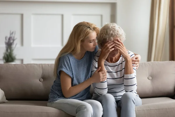 Besorgnis erregende blonde junge Frau beruhigt frustrierte Mutter mittleren Alters. — Stockfoto