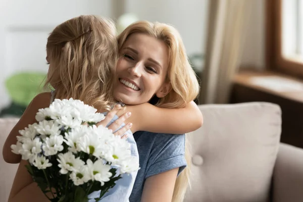 Agradecida joven rubia madre abrazando a la pequeña hija . — Foto de Stock