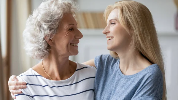 Sonriente de mediana edad madura mujer abrazo atractivo crecido hija . — Foto de Stock