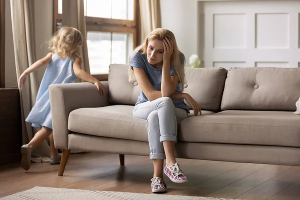 Infeliz mami joven cansado de niña pequeña hiperactividad . — Foto de Stock