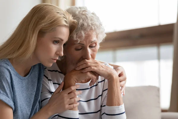 Empathic daughter embracing desperate middle aged mother. — Stock Photo, Image