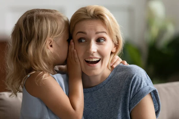 Pequena menina pré-escolar compartilhando segredo com a mamãe . — Fotografia de Stock